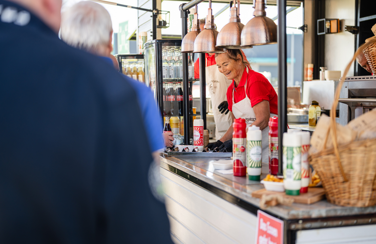 Eine Frau, die in einem Food-Truck steht und arbeitet.