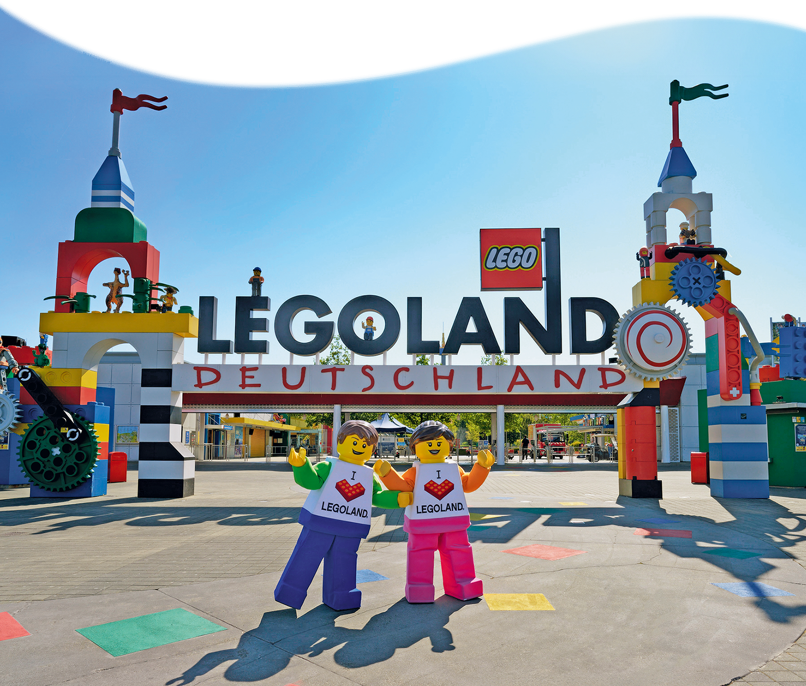 Eingangsbereich des Legoland Deutschland Parks mit zwei lebensgroßen Legofiguren davor